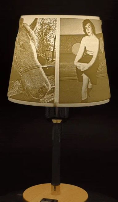 A lit Magic Memory Lamp. On it is a horse's head and a woman sitting on a couch.  www.lightmymemory.com Light My Memory